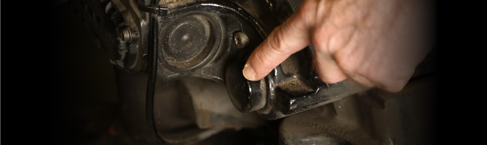 Technician checking a guide pin cap on the back of a heavy-duty air disc brake caliper