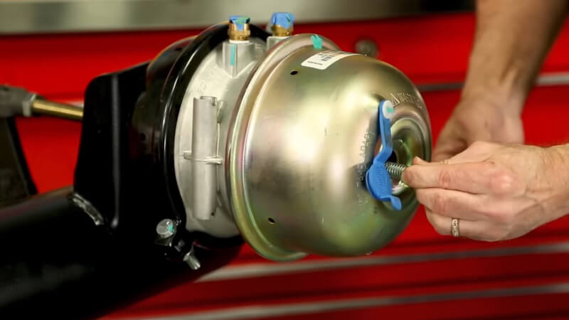Man inserting bolt in HD vehicle brake chamber