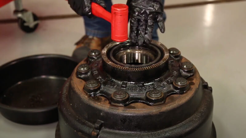 man gently tapping wheel end with rubber mallet to ensure it is in place