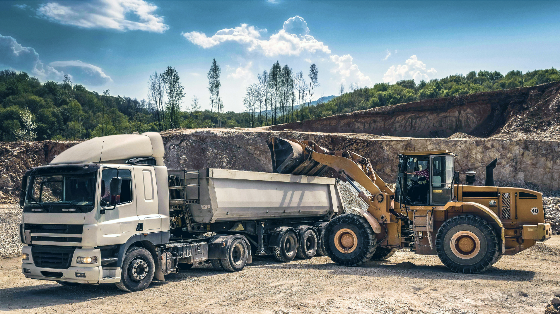 loader dumping dirt into semi truck
