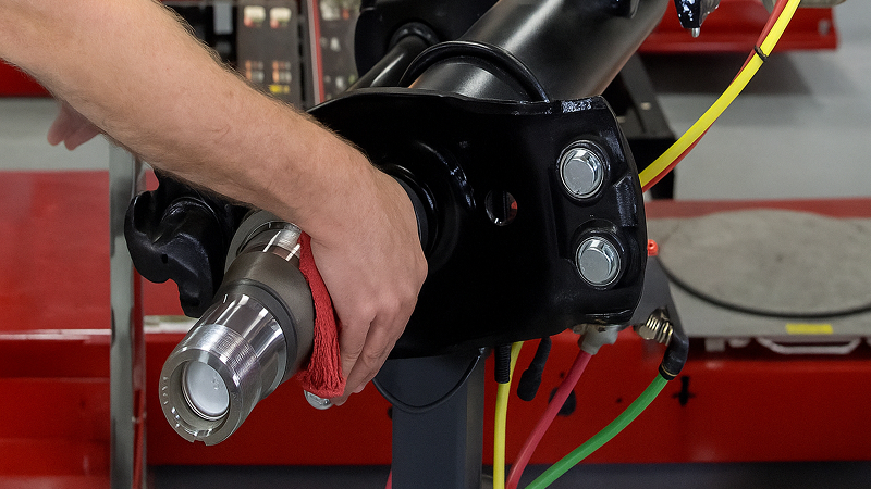 man cleaning spindle with rag