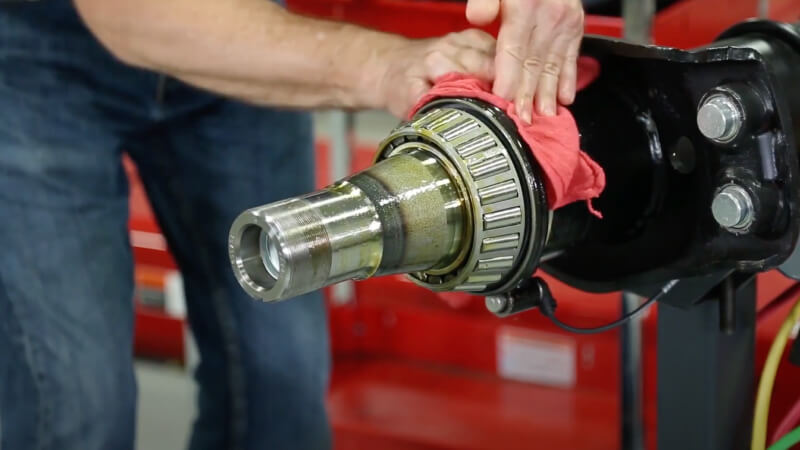 Man wiping excess oil from seal backside